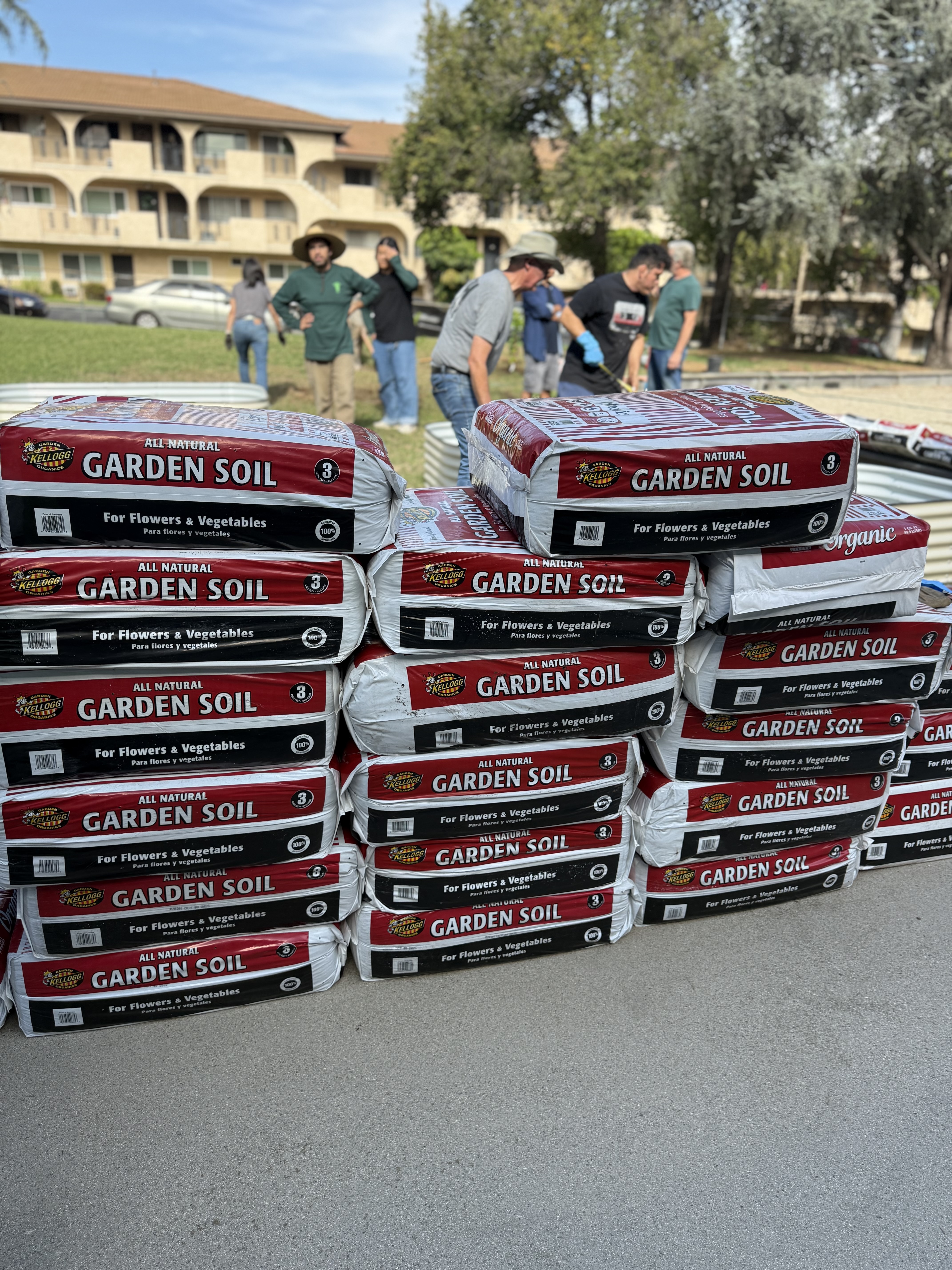 Community garden soil supplies and volunteers preparing the garden at The Grace Place